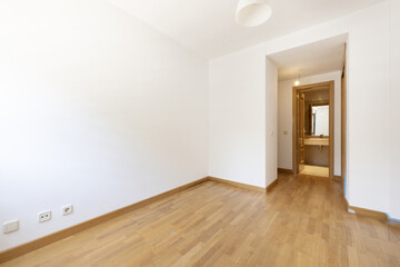 Empty room in a house with an oak floor, a dressing area and a toilet with a cream marble top