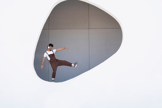 Young man enjoying on wall of building