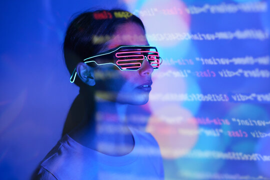 Woman with futuristic glasses reading codes on glowing background