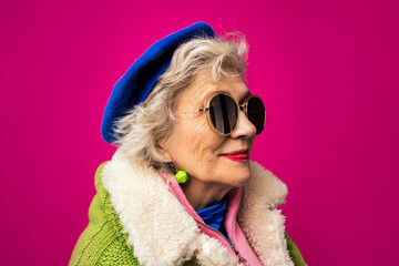 Fashionable woman wearing sunglasses against pink background