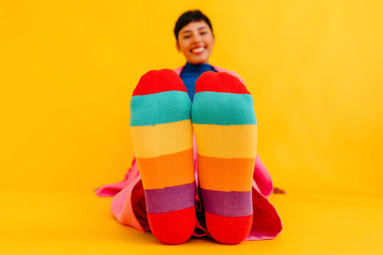 Woman wearing colorful socks over yellow background