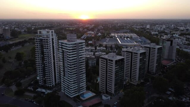 Toma aerea descendente de torres en un atardecer de verano en la ciudad de Rosario, Argentina