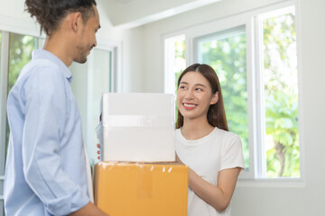 Happy family asian young wife and husband or couple holding carton parcel, carry cardboard box for preparing moving relocation, new home, apartment. Mortgage, real estate, loan for house owner concept