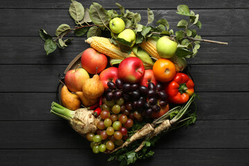 Different fresh vegetables and fruits on black wooden table, top view. Farmer harvesting