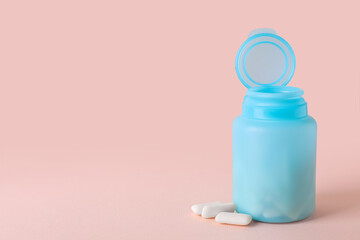 Jar with chewing gums on light pink background. Space for text