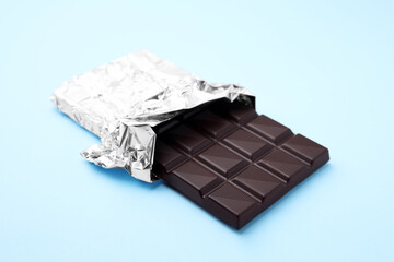 One tasty chocolate bar on light blue background