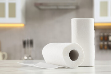 Rolls of paper towels on white marble table in kitchen. Space for text