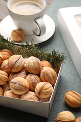 Box with delicious nut shaped cookies on table, closeup