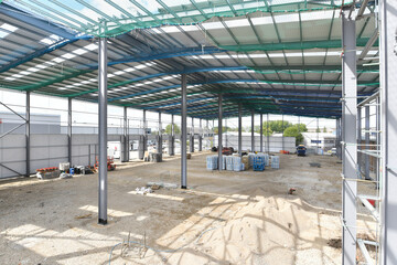 construction site of commercial warehouse building showing various materials and frame of building - 576033574
