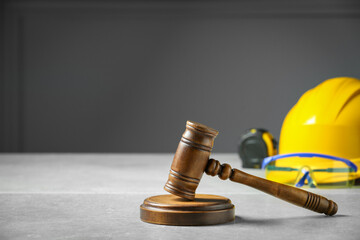 Construction and land law concepts. Judge gavel, tape measure with hardhat on light grey table, space for text