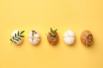 Festively decorated chicken eggs on yellow background, flat lay. Happy Easter
