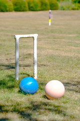 a hoop, post and 2 balls from a game of Croquet in a garden - 576033948