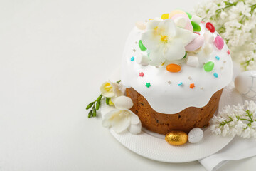 Traditional Easter cake with painted eggs and flowers on white table, space for text