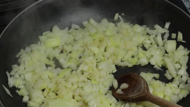 morceaux d'oignons  cuisant, en gros plan, dans une po&ecirc;le