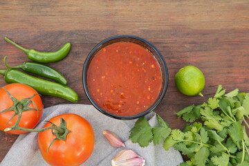 Flat lay composition of tasty salsa sauce and different ingredients on wooden table
