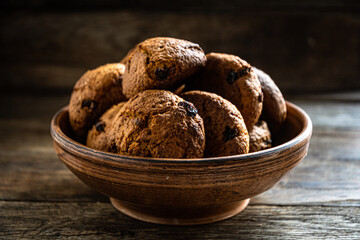 Homemade oatmeal cookies in a ceramic bowl on the kitchen table.