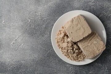 Compressed yeast on grey table, top view. Space for text