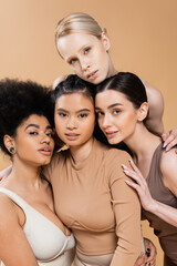 Fototapeta premium sensual multicultural models in underwear looking at camera isolated on beige.
