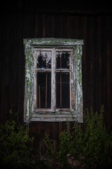 An old flaked window with white wooden frame