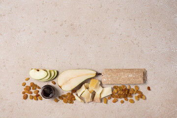 Creative cheese platter. Variety soft and hard cheeses, fruit, jam on beige concrete background....