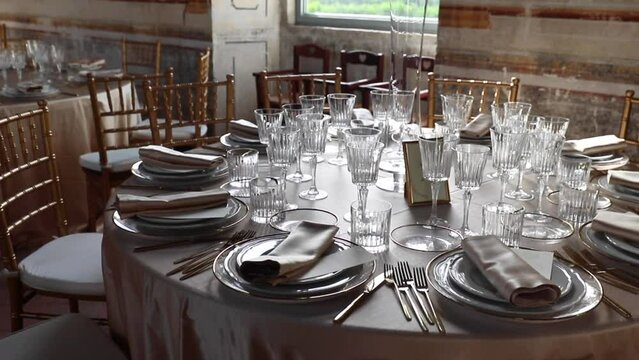 Wedding Day, catering and food. Details of an Hall of an ancient castle with catering for wedding events. The tables are set up with fine plates, glasses and cutlery