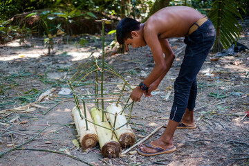 Village kids of Bangladesh making raft by sticks , and bark of banana tree