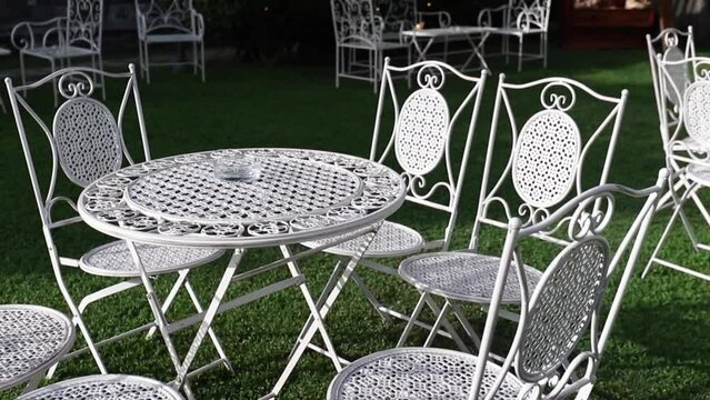Wedding Day, catering and food. Details of an elegant and antique white tables and chairs during a wedding ceremony event on summer