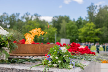 eternal flame of the monument of the war. A symbol of memory of the people about the fallen heroes. May 9, Victory Day. Selective focus.Flowers at memorial to tomb of Unknown Soldier