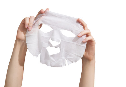 Female hands holding sheet of white mask on transparent background