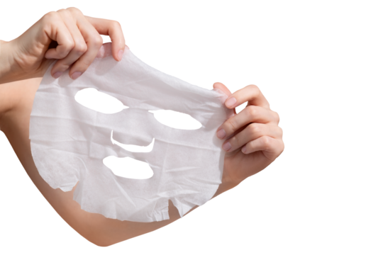 Female hands holding sheet of white mask on transparent background