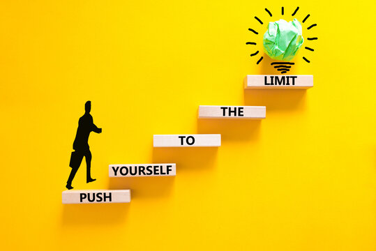 Push the limit symbol. Concept words Push yourself to the limit on wooden blocks. Beautiful yellow table yellow background. Businessman icon. Business push the limit concept. Copy space.