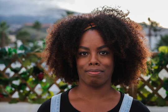 Close-up Of A Young Woman With Afro-style Hair On The Terrace Of Her House At Sunset. Concept: Lifestyle, Outdoors, Serious