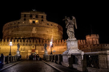 Fototapeta na wymiar Castel Sant Angelo and angel statue on Saint Angelo bridge in Rome Italy at night