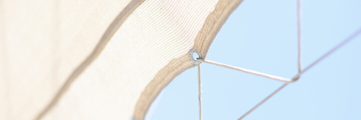 Beach umbrella on stretched rope closeup. Quality parasol