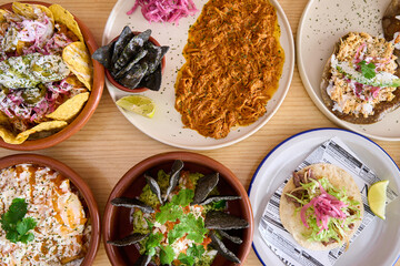 Top view of a set of different Mexican dishes on a wooden table