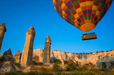 Fototapeta na wymiar Cappadocia Love Valley, Hot air balloon flying over unique geological formations Fairy Chimneys in Goreme National Park, Popular tourist destination in Turkey