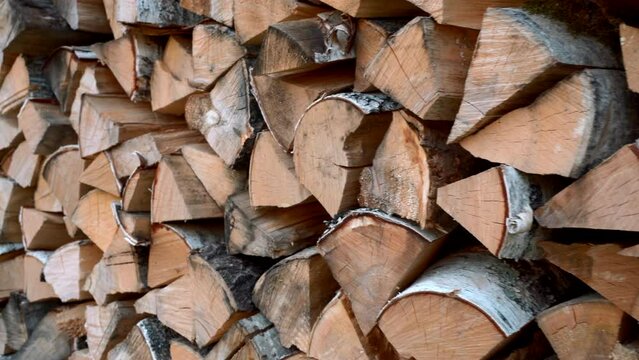 Close up of dry chopped tree trunks are laid in rows. Media. Stacked firewood prepared for the fireplace and stove.