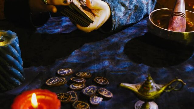 Fortune teller hands with rings by candlelight in the twilight fortune telling by tarot cards on a dark velvet table