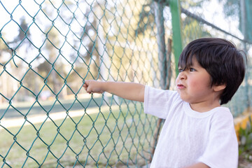 Mexican innocent child playing at fence