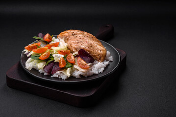 Delicious healthy breakfast consisting of chicken, rice, greens and cherry tomatoes