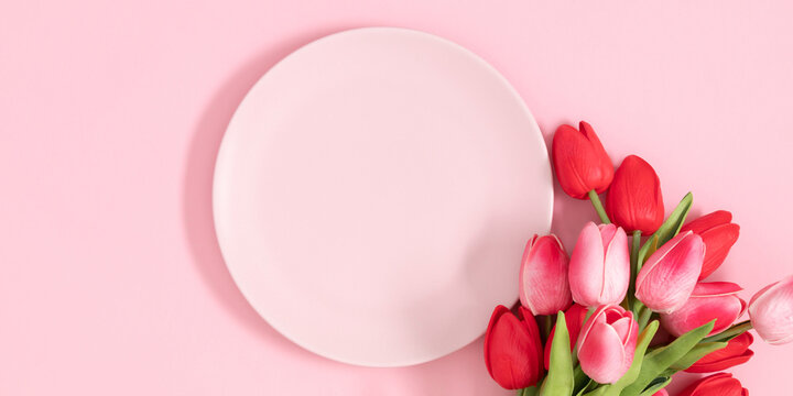 Flowers composition romantic. Flowers pink tulips and pink empty plate on pastel pink background. Wedding. Birthday. Happy woman's day. Mothers Day. Valentine's Day. Flat lay, top view, copy space
