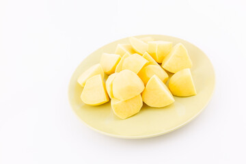 Raw peeled potatoes in glass plate on white background