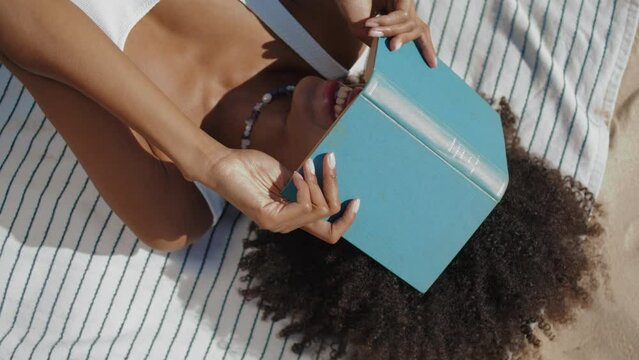 Girl hiding face book resting on beach closeup. Playful woman enjoying summer