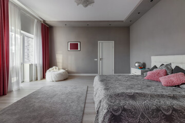Beautiful interior design of a modern and cozy bedroom with pink pillows and curtains