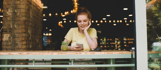 Cheerful woman resting with smartphone in cafe