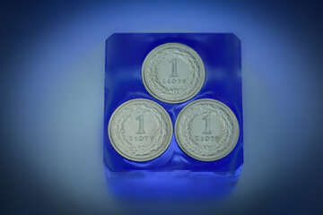3x coin of Polish zloty on a glass base dipped in water. The whole in blue tones. National Bank of...