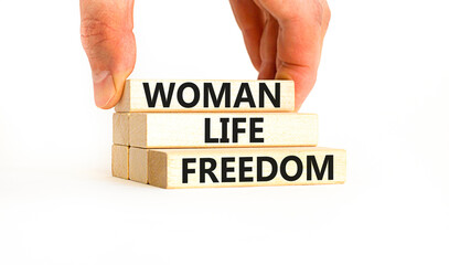 Woman life freedom symbol. Concept words Woman Life Freedom on wooden blocks on a beautiful white table white background. Businessman hand. Social issue woman life freedom concept. Copy space.