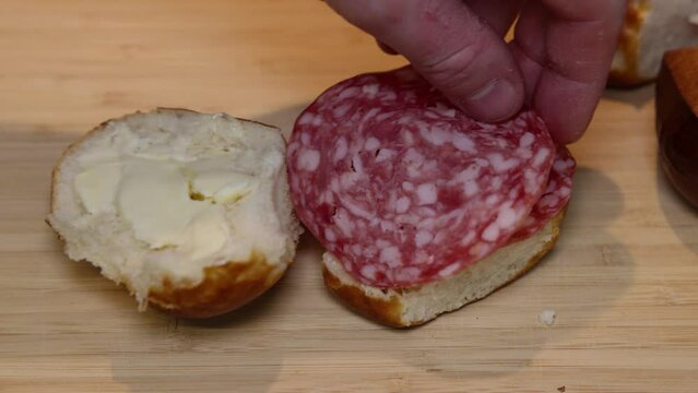 A piece of salami is placed on a lye bread smeared with butter.