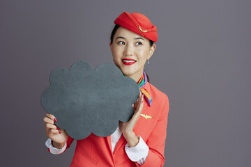 asian female air hostess showing blank cloud shape board