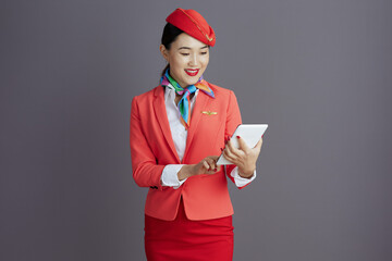 happy elegant asian female air hostess isolated on gray